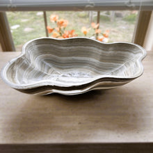 Load image into Gallery viewer, A polished and shine gray onyx stone bowl with natural patterns placed on a flat surface, likely used as a decorative centerpiece.
