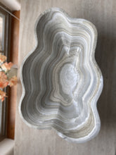 Load image into Gallery viewer, A polished and shine gray onyx stone bowl with natural patterns placed on a flat surface, likely used as a decorative centerpiece.

